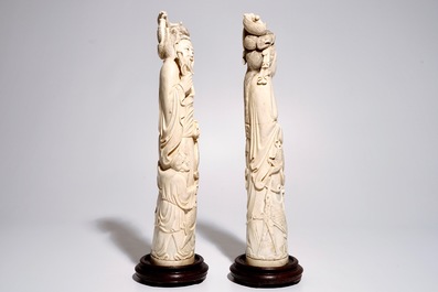 Een paar grote Chinese ivoren sculpturen van een man en vrouw met vissen, 19/20e eeuw